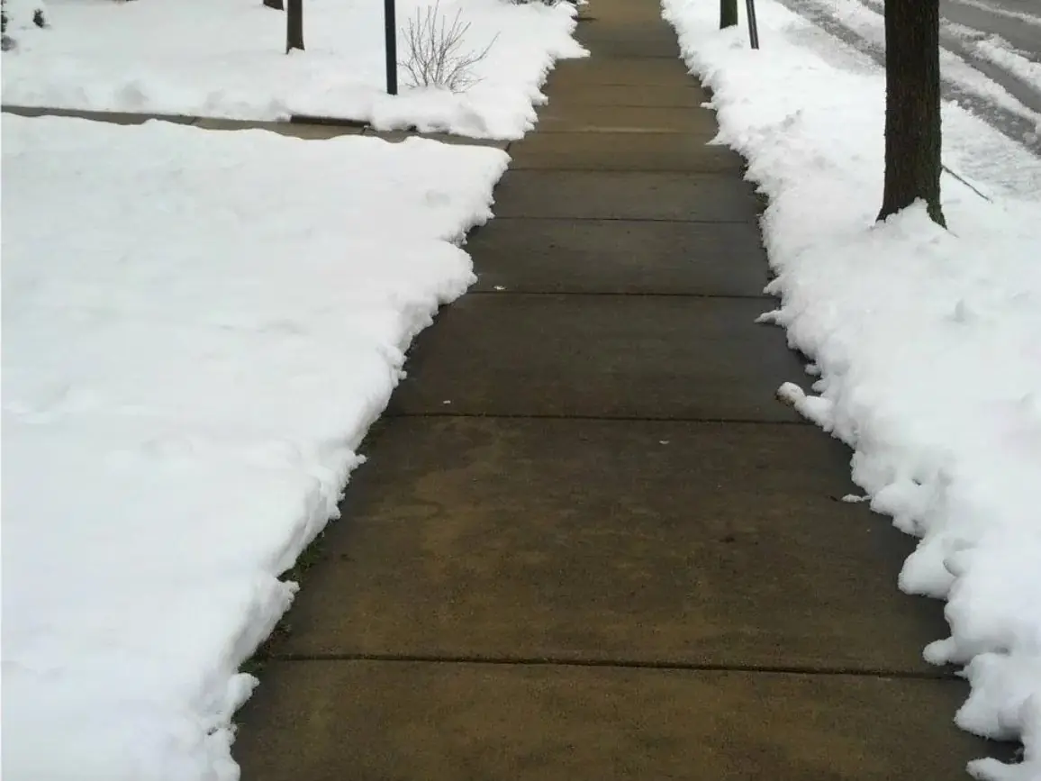 A cleared sidewalk after snow removal